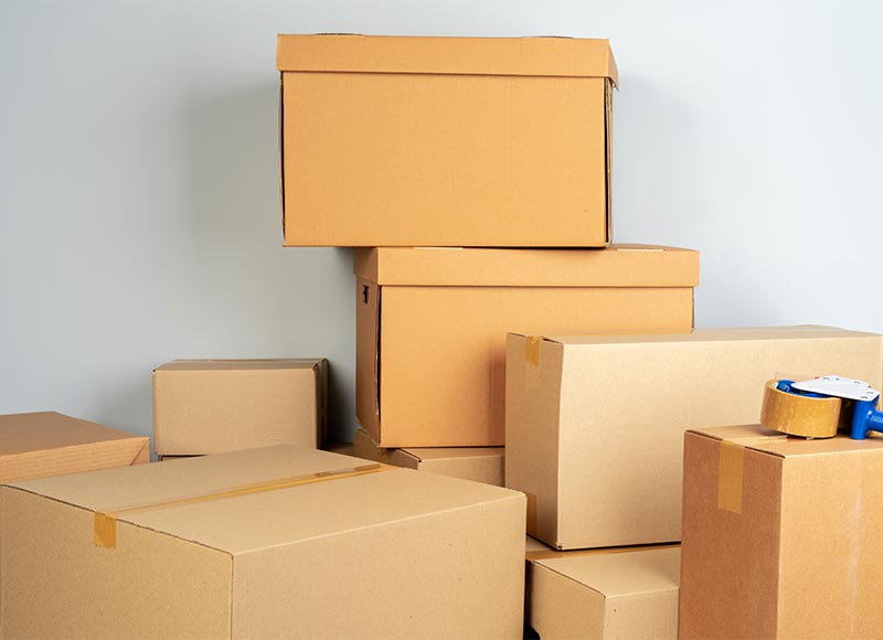 Movers and packers organizing items by room, avoiding mixing in the same box for efficiency.