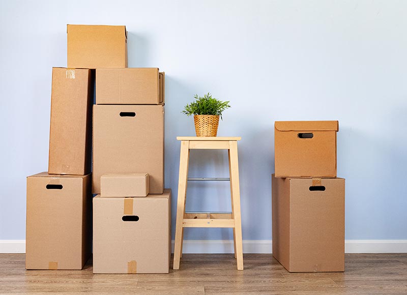 Movers and packers using sturdy boxes to pack fragile items securely for a safe move